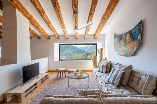 Salón con vigas de madera y gran ventana panorámica