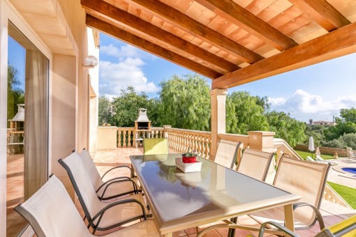 Terraza cubierta con zona de estar y zona de barbacoa