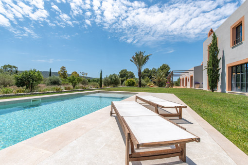 Piscina de 14 x 4 metros con amplia terraza soleada rodeada de naturaleza mediterránea