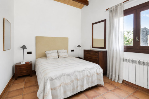 Dormitorio sencillo con muebles de madera y ventana