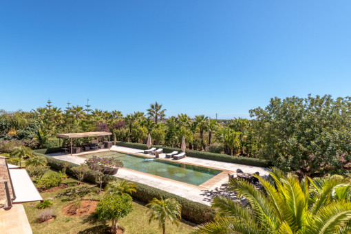 Zona de piscina rodeada de jardín