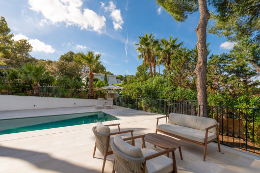 Jardín con zona lounge y piscina