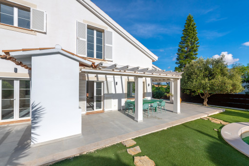 Terraza cubierta y jardín bien cuidado