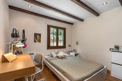 Dormitorio acogedor con vigas de madera
