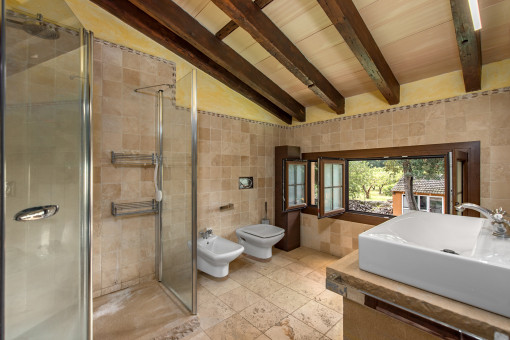 Segundo baño con piedra natural y vistas al jardín