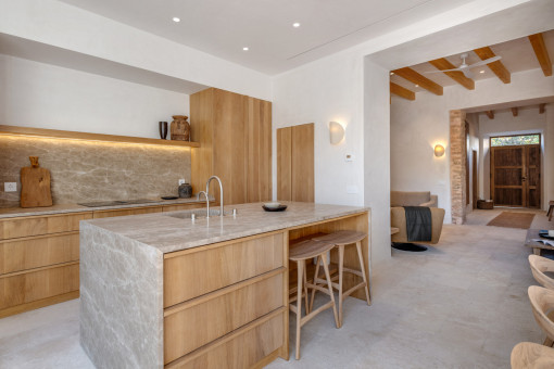 Cocina abierta con isla de piedra y vistas al salón