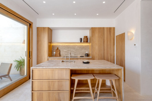 Cocina luminosa de diseño con materiales naturales y acceso al patio 