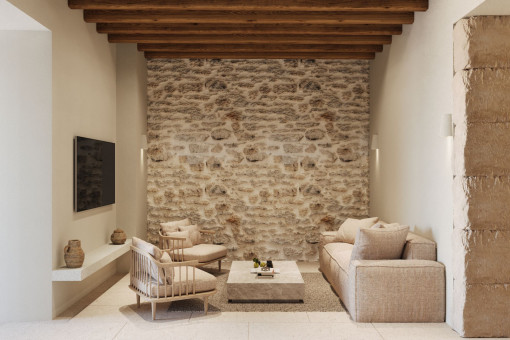  Salón con pared de piedra y vigas vistas – tradición mallorquina reinterpretada con estilo