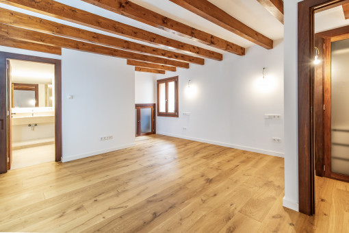 Dormitorio con baño en suite y vestidor