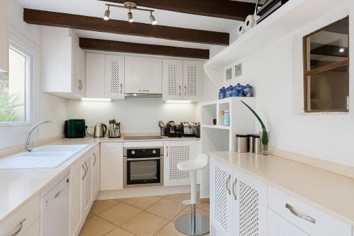 Cocina moderna blanca con vigas