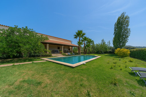 Jardín mediterráneo con piscina y terraza cubierta