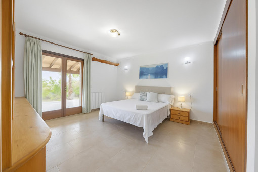 Dormitorio doble luminoso y elegante con acceso directo a la terraza cubierta y vistas al jardín.
