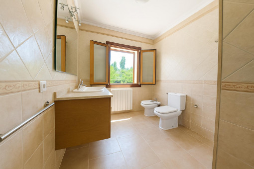 Baño de invitados moderno con bidé y ventana – cómodo y funcional.