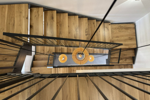 Vista del hueco de escalera abierto con madera y acero