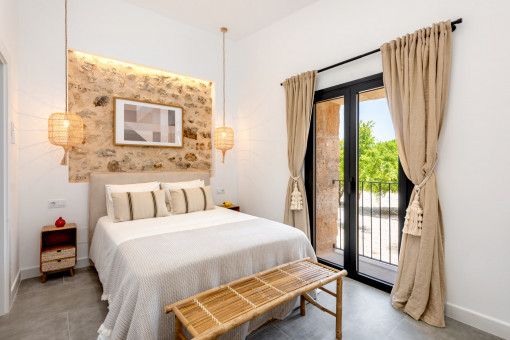 Dormitorio acogedor con pared de piedra 
