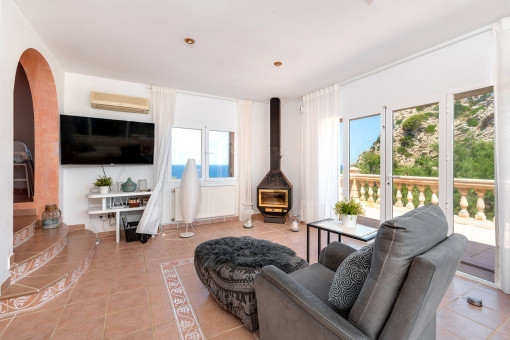 Salón luminoso con chimenea y acceso a la soleada terraza con vistas abiertas