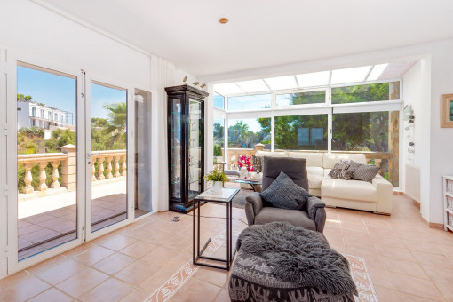 Salón luminoso con chimenea y acceso a la soleada terraza con vistas abiertas