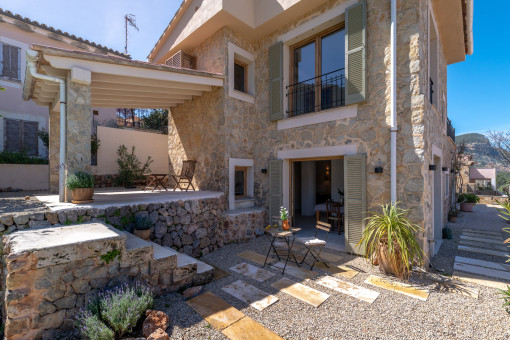 Vista lateral de la fachada de piedra natural y el porche 