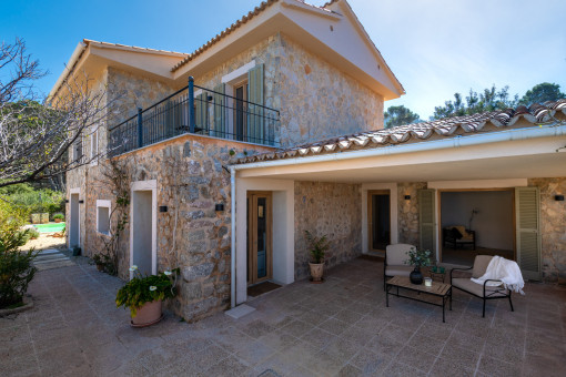 Vista lateral de la fachada de piedra natural y el porche de entrada