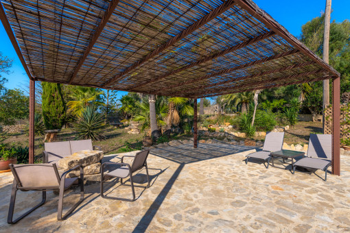 Terraza con pérgola en el jardín mediterráneo de la finca