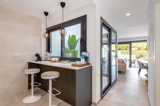 Cocina abierta con barra de desayuno y vistas al pequeño patio interior