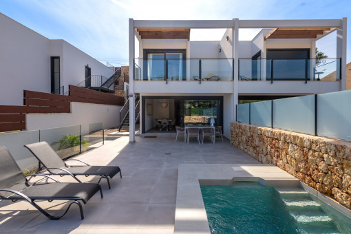 Vista exterior de la casa con piscina y terraza solárium