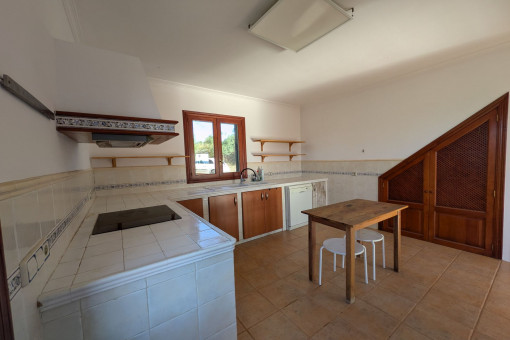 Cocina espaciosa con muebles de madera, electrodomésticos y acceso al jardín