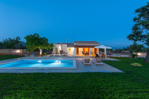 Vista exterior con piscina de noche