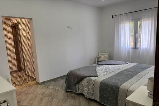 Dormitorio con cama doble, vestidor y baño en suite