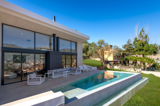 Piscina infinity con solárium y zona lounge integrada