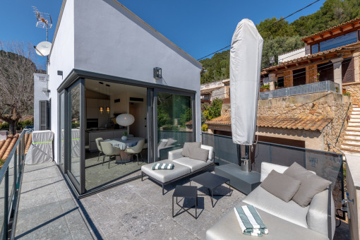 Terraza en la azotea moderna con zona de estar y acceso a la cocina abierta