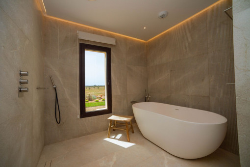 Baño principal de lujo con piedra natural y elegante bañera