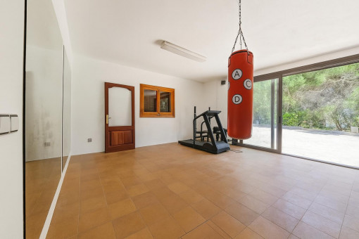 Gimnasio en casa con saco de boxeo y espejo