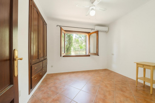 Habitación vacía con armario de madera y ventana