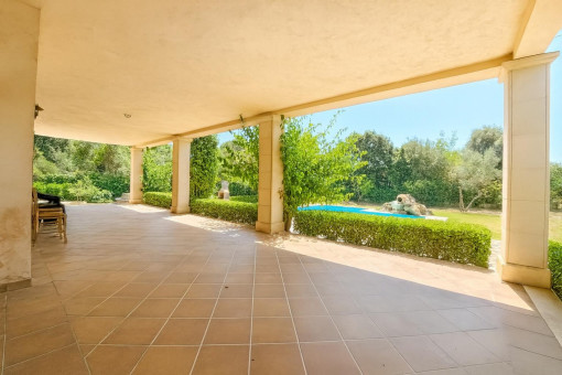 Terraza cubierta con piscina y jardín