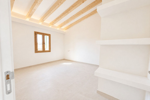 Dormitorio con techos altos y vigas de madera vistas