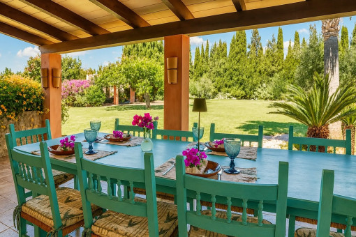 Terraza cubierta con mesa de comedor y vista al jardín