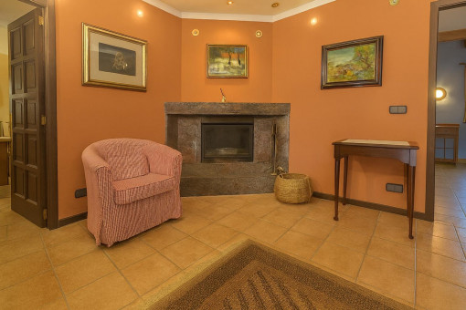 Acogedor pasillo con chimenea y sillón