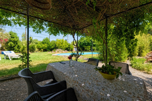 Comedor cubierto con vistas a la piscina y al jardín