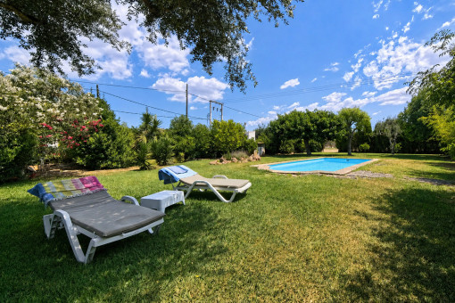Piscina con tumbonas en el cuidado jardín