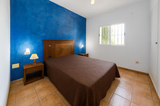 Dormitorio con pared azul decorativa