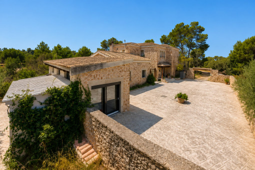 Casa principal y casa de invitados con patio de piedra