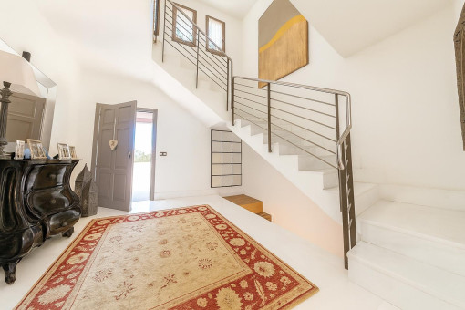 Pasillo luminoso con escalera y alfombra