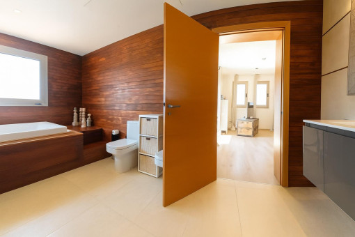 Baño moderno con bañera y paneles de madera