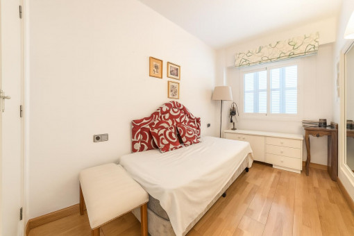 Dormitorio pequeño con ventana y suelo de madera