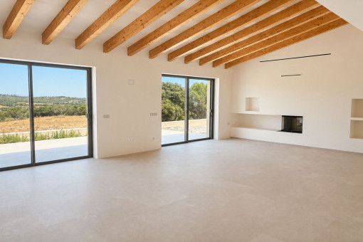 Luminoso salón con vigas de madera y chimenea
