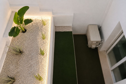 Patio de luz ajardinado con iluminación ambiental