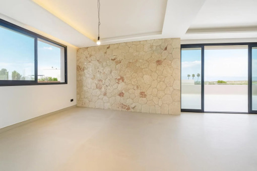 Salón y comedor diáfanos con pared de piedra natural