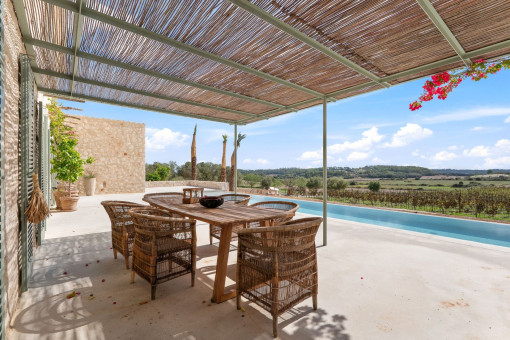 Comedor exterior cubierto con vistas a la piscina