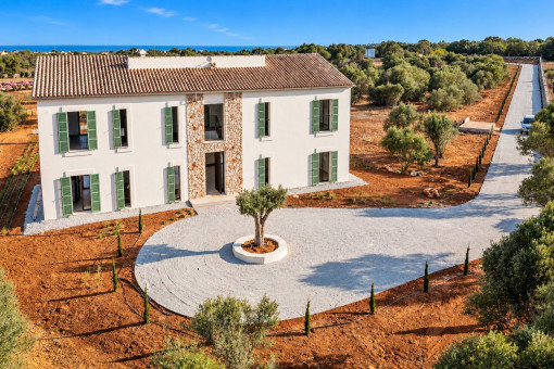 Acceso a la finca con rotonda ajardinada y olivo central